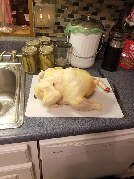 A thawed out whole chicken on a cutting board