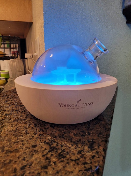 Young Living Essential Oils Diffuser running with a blue light on