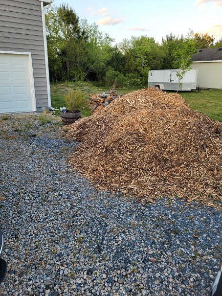 A large pile of wood chips in the driveway