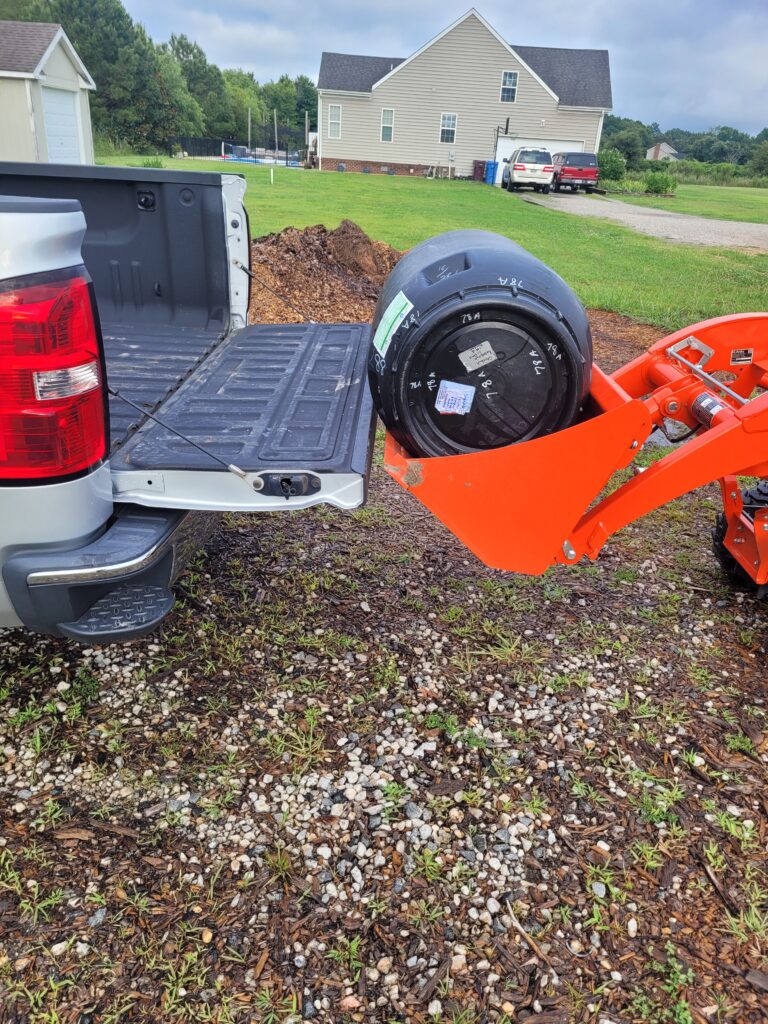 Tractor Bucket level with a truck tailgate with a 55 gallon feed barrel 